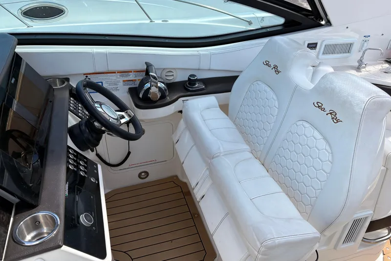 Slide: The Image of 2019 Sea Ray Sundancer 320 helm with white leather seats and modern controls. - 19
