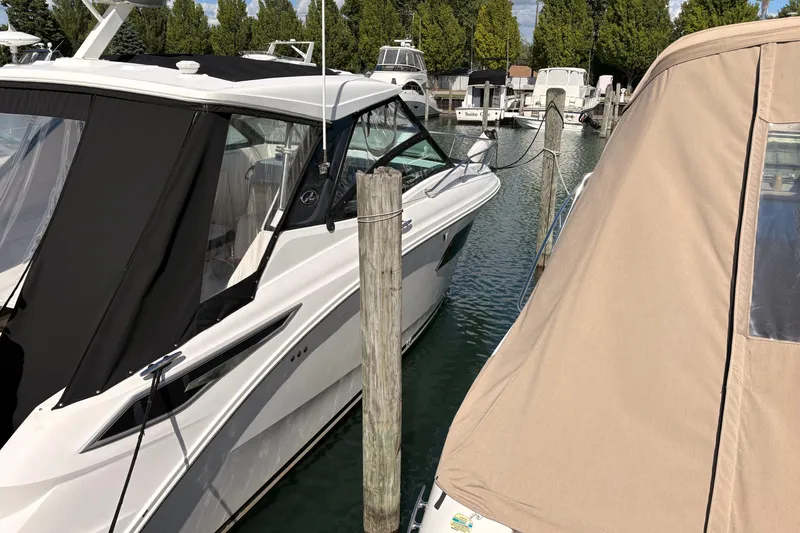 Slide: The Image of 2019 Sea Ray Sundancer 320 docked at a marina, surrounded by other boats. - 4