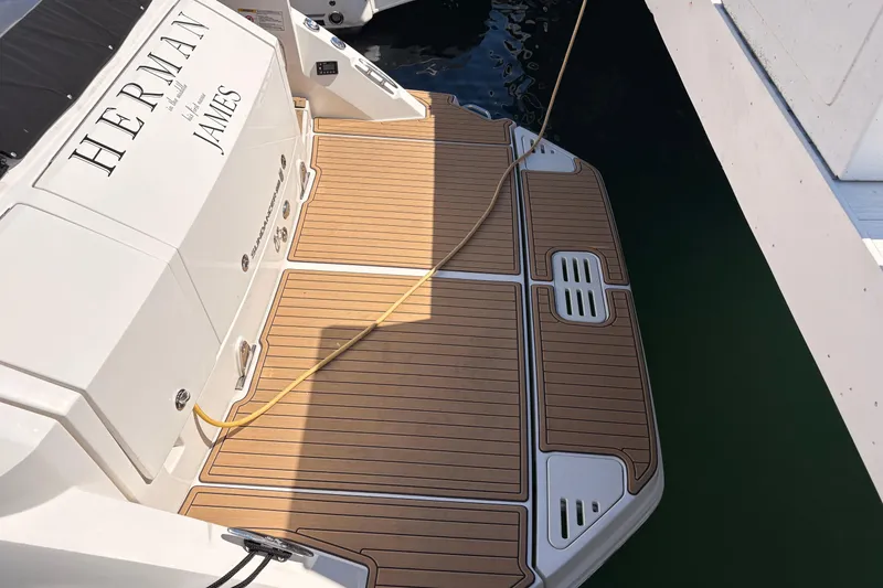 Slide: The Image of 2019 Sea Ray Sundancer 320 boat docked, featuring teak swim platform and mooring line. - 5