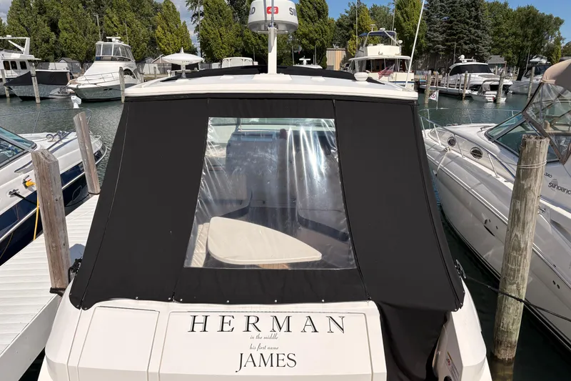 Slide: The Image of 2019 Sea Ray Sundancer 320 docked at marina, rear view with black cover. - 1