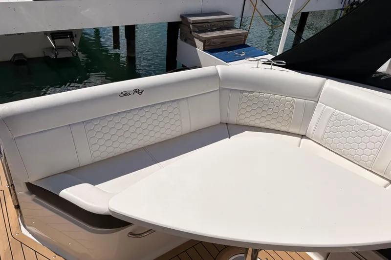 Slide: The Image of Luxurious seating area on a 2019 Sea Ray Sundancer 320 yacht, featuring elegant white upholstery. - 7