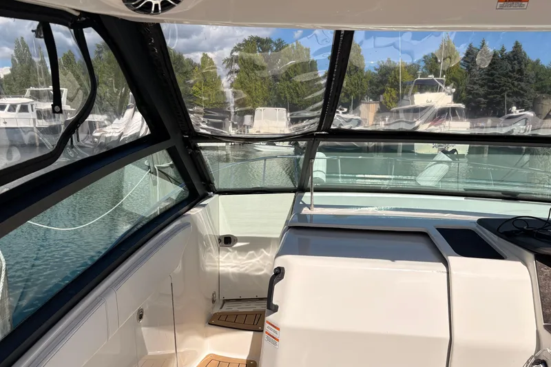 Slide: The Image of Interior view of a 2019 Sea Ray Sundancer 320 boat with clear windows and docked yachts outside. - 9