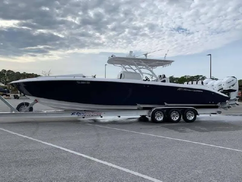 Slide: The Image of 2019 Midnight Express 39 Cuddy boat on trailer under cloudy sky. - 0