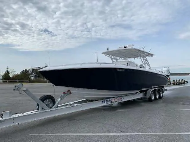 Slide: The Image of 2019 Midnight Express 39 Cuddy boat on trailer under cloudy sky. - 1