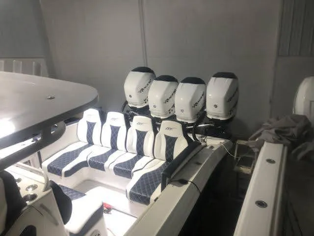 Slide: The Image of 2019 Midnight Express 39 Cuddy boat with multiple outboard engines in a garage. - 5