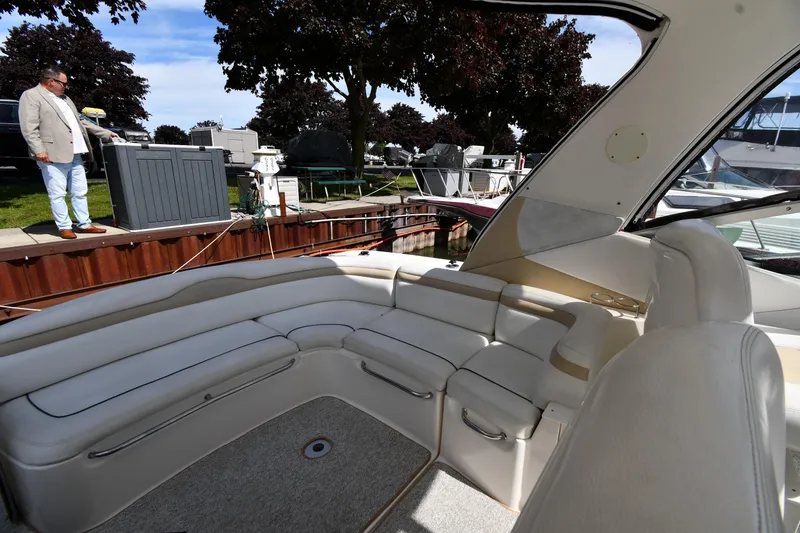 Slide: The Image of 2008 Sea Ray Sundancer 350 interior with spacious seating, docked near a marina. - 25