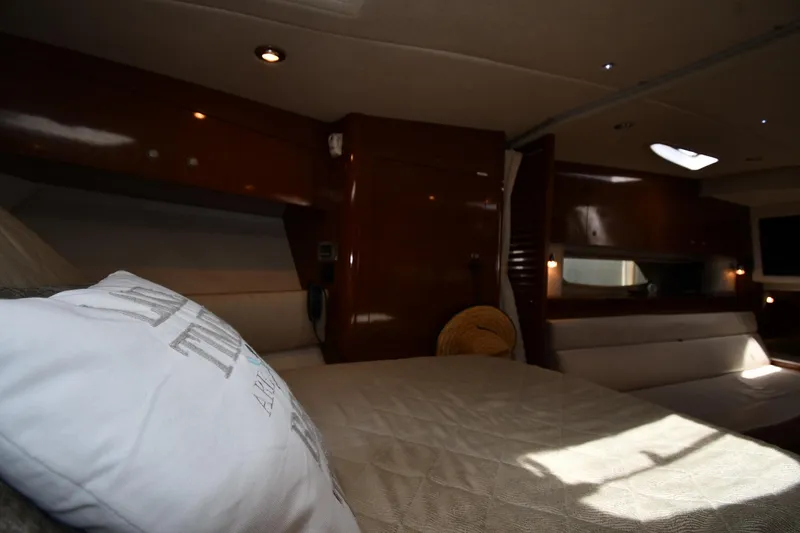 Slide: The Image of Interior cabin of 2008 Sea Ray Sundancer 350 yacht, featuring cozy bedding and elegant wood finishes. - 30
