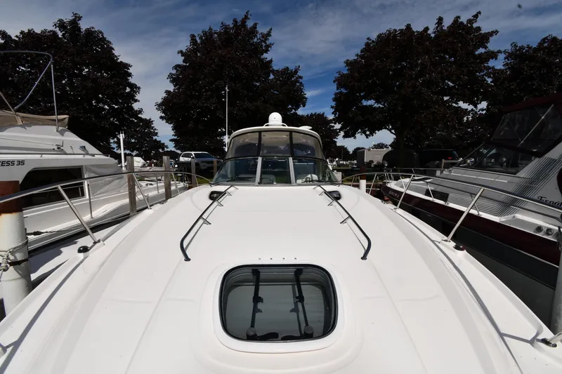 Slide: The Image of 2008 Sea Ray Sundancer 350 yacht docked, showcasing sleek design and spacious deck. - 6