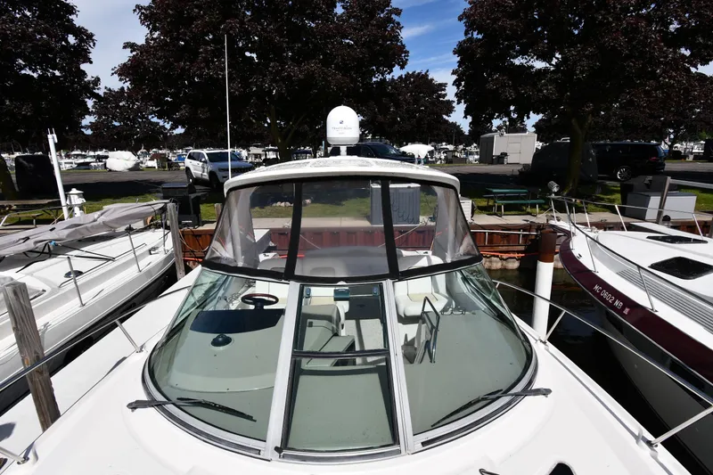 Slide: The Image of 2008 Sea Ray Sundancer 350 docked at marina, surrounded by trees and parked vehicles. - 7