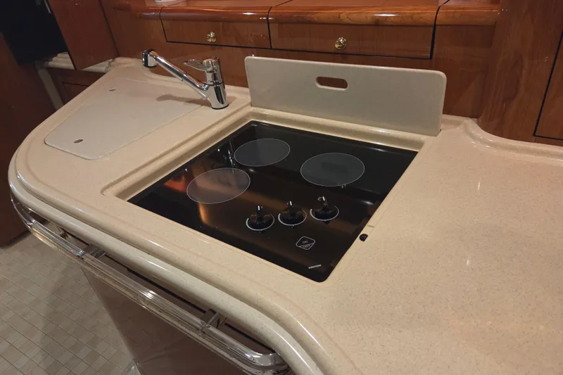 Slide: The Image of Luxurious kitchen area in 2000 Sea Ray Sundancer 540 yacht with stovetop and sink. - 27