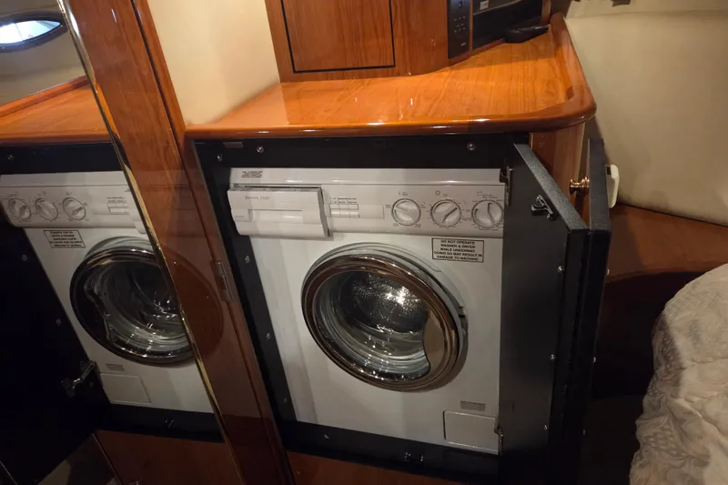 Slide: The Image of Laundry area inside a 2000 Sea Ray Sundancer 540 yacht, featuring a compact washing machine. - 29