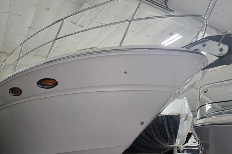 Slide: The Image of 2000 Sea Ray Sundancer 540 yacht in indoor storage, showcasing sleek design and polished exterior. - 57
