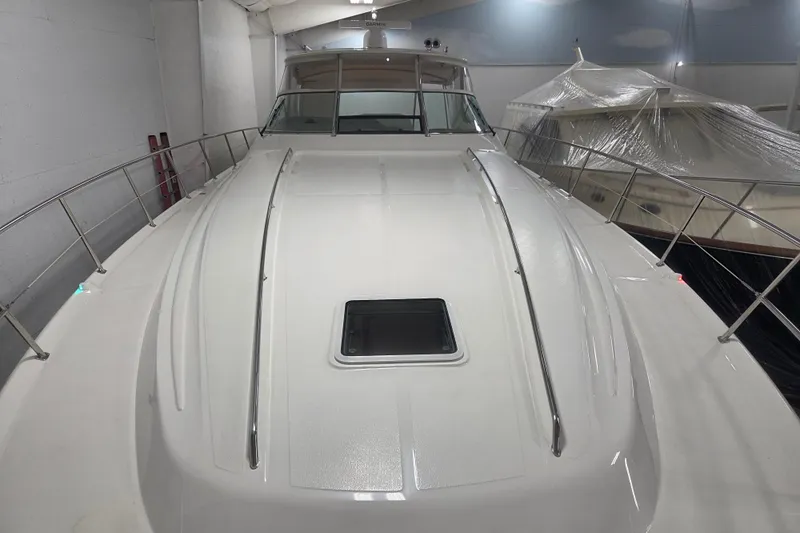 Slide: The Image of 2000 Sea Ray Sundancer 540 yacht in indoor storage, showcasing sleek deck design. - 58
