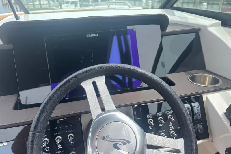 Slide: The Image of 2024 Sea Ray SDX 290 Outboard dashboard with steering wheel and control panel. - 17