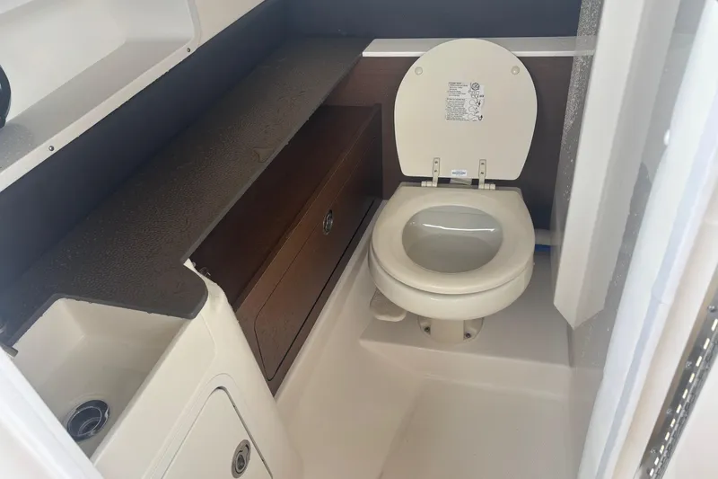 Slide: The Image of 2024 Sea Ray SDX 290 Outboard boat bathroom with toilet and storage cabinet. - 19