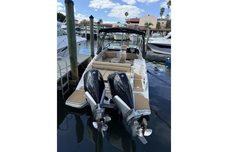Slide: The Image of 2024 Sea Ray SDX 290 Outboard docked, featuring dual engines and spacious seating. - 2