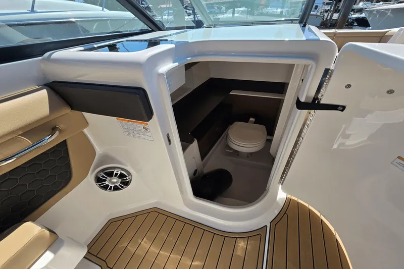 Slide: The Image of 2024 Sea Ray SDX 290 Outboard boat interior with compact marine toilet and seating area. - 4