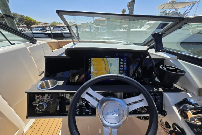 Slide: The Image of 2024 Sea Ray SDX 290 Outboard dashboard with navigation display and steering wheel. - 5