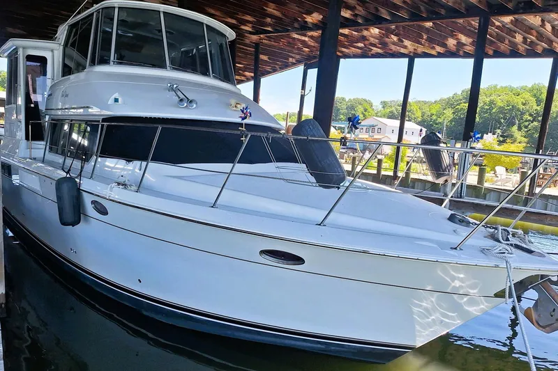 The Image of 1997 Carver 500 Cockpit Motor Yacht docked under a wooden canopy. - 1