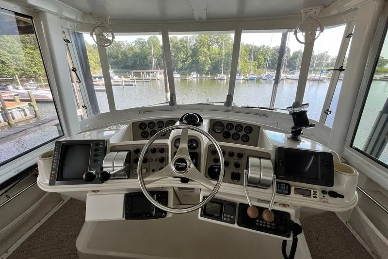 Slide: The Image of Cockpit view of 1997 Carver 500 Cockpit Motor Yacht with steering wheel and control panels. - 13