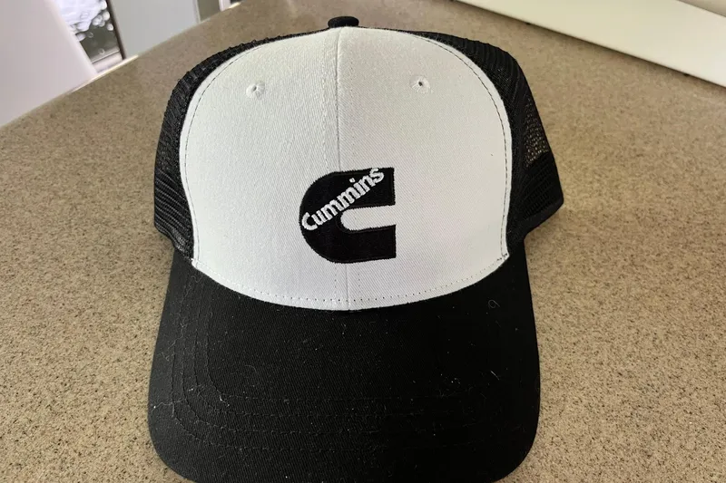 Slide: The Image of Black and white Cummins trucker hat on a countertop. - 16