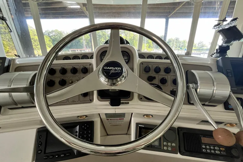 Slide: The Image of Steering wheel of a 1997 Carver 500 Cockpit Motor Yacht, showcasing control panel and throttle levers. - 17
