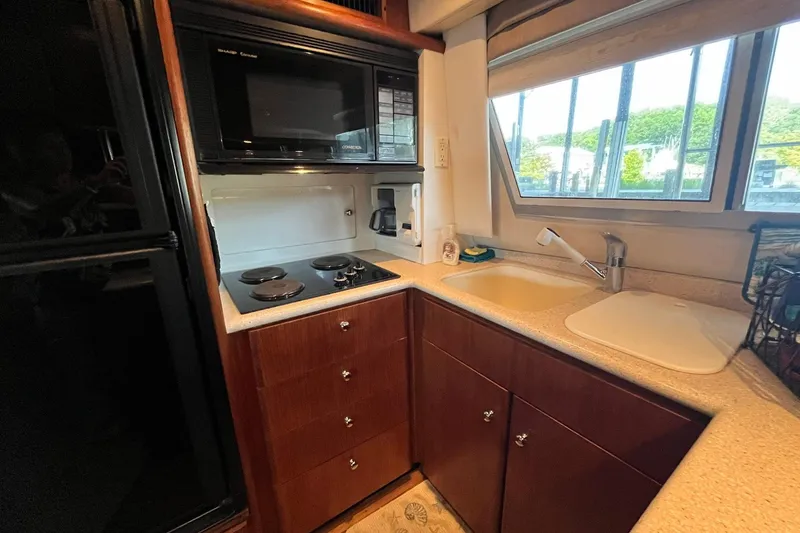 Slide: The Image of Compact kitchen in a 1997 Carver 500 Cockpit Motor Yacht with stove, microwave, and sink. - 32