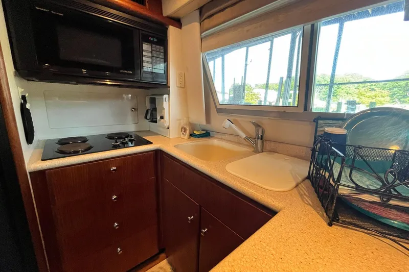 Slide: The Image of Compact kitchen in a 1997 Carver 500 Cockpit Motor Yacht with stove, microwave, and sink. - 34