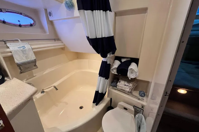 Slide: The Image of Bathroom in 1997 Carver 500 Cockpit Motor Yacht with tub, striped curtain, and towels. - 42