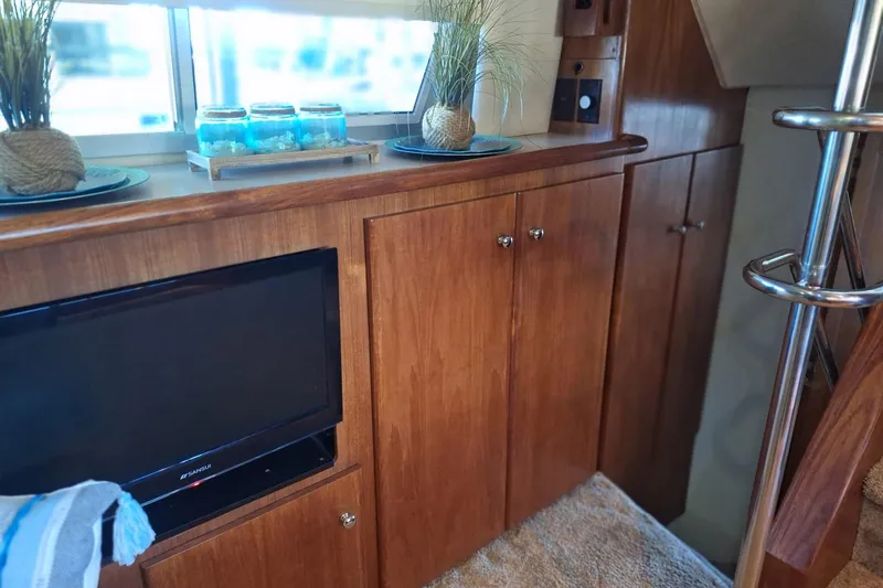Slide: The Image of Interior of 1997 Carver 500 Cockpit Motor Yacht with wooden cabinets and TV. - 47