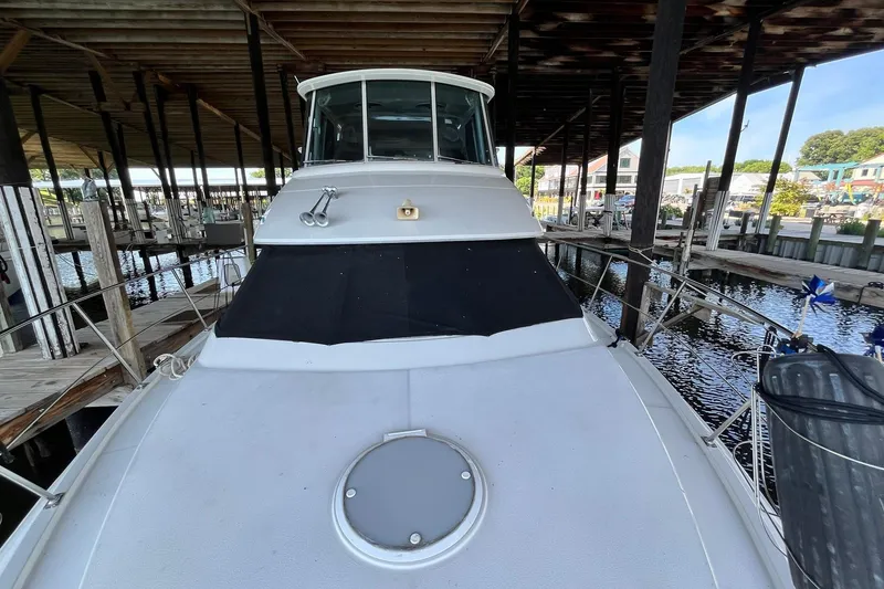 Slide: The Image of 1997 Carver 500 Cockpit Motor Yacht docked in a marina under a covered structure. - 5