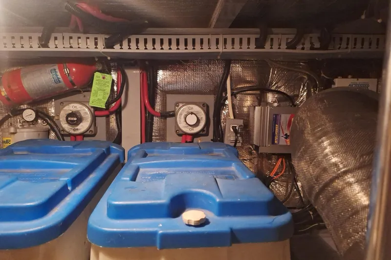 Slide: The Image of Engine room of a 1997 Carver 500 Cockpit Motor Yacht with batteries and fire extinguisher. - 62