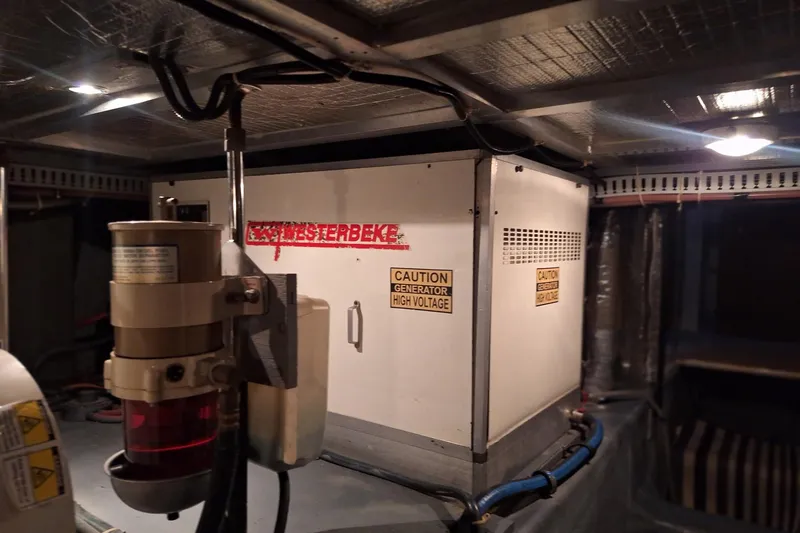 Slide: The Image of Engine room of 1997 Carver 500 Cockpit Motor Yacht with generator and caution signs. - 64