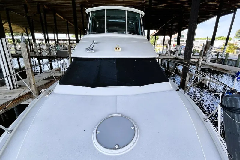 Slide: The Image of 1997 Carver 500 Cockpit Motor Yacht docked under a covered marina. - 66