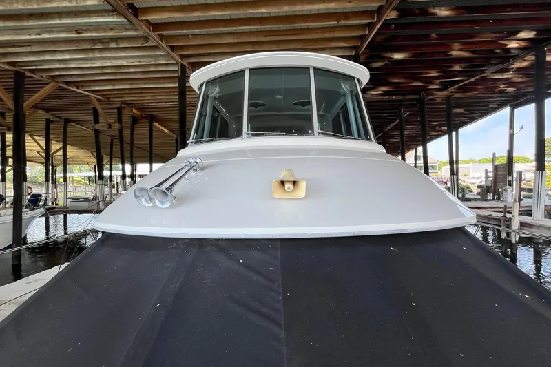 Slide: The Image of 1997 Carver 500 Cockpit Motor Yacht docked under a wooden shelter. - 67