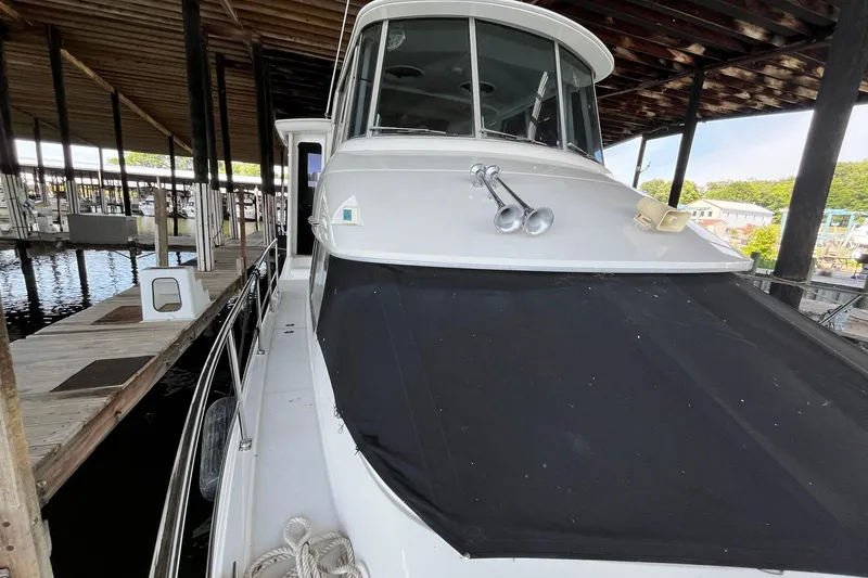 Slide: The Image of 1997 Carver 500 Cockpit Motor Yacht docked under a covered marina. - 68