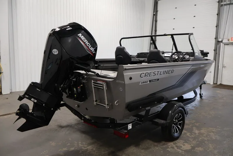 Slide: The Image of 2026 Crestliner 1650 Hawk WT boat with Mercury outboard motor in a garage setting. - 12