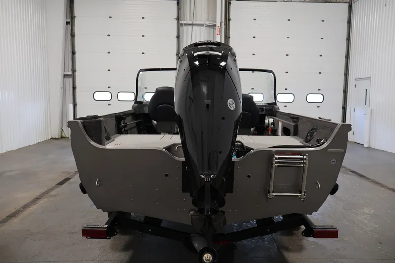 Slide: The Image of 2026 Crestliner 1650 Hawk WT boat in a garage, rear view with motor. - 14