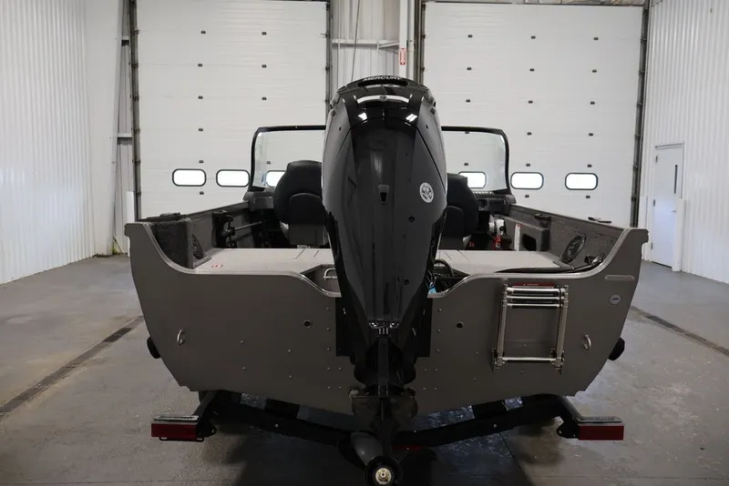 Slide: The Image of 2026 Crestliner 1650 Hawk WT boat in a garage, rear view with motor. - 14