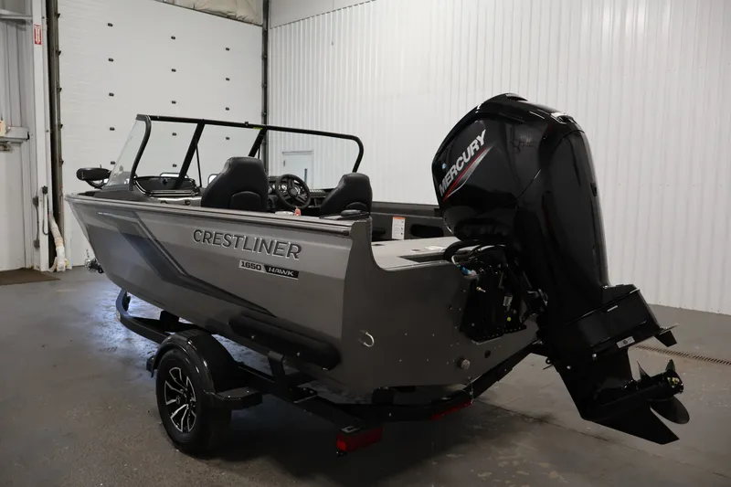 Slide: The Image of 2026 Crestliner 1650 Hawk WT boat with Mercury outboard motor in a garage setting. - 15