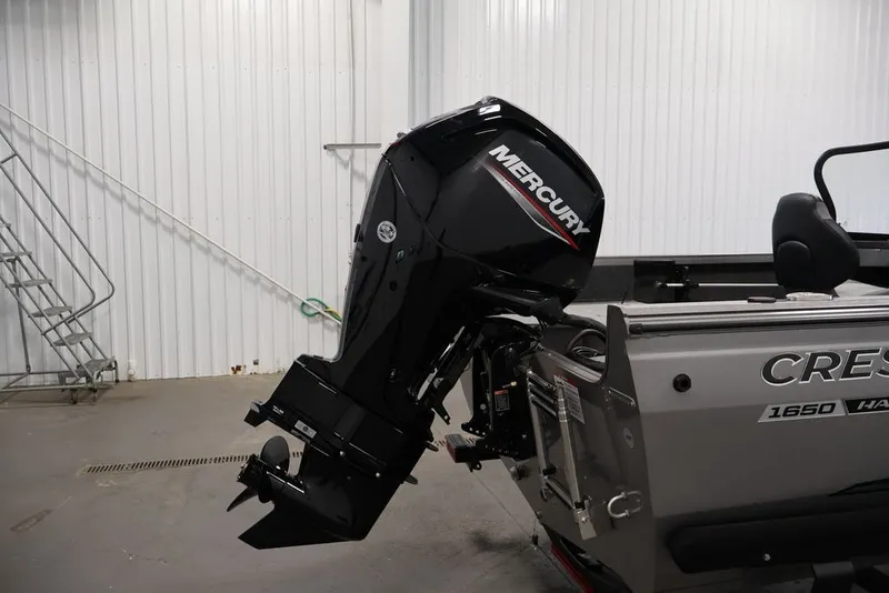 Slide: The Image of 2026 Crestliner 1650 Hawk WT boat with Mercury outboard motor in a garage. - 37