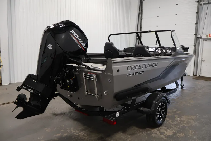 Slide: The Image of 2026 Crestliner 1650 Hawk WT boat with Mercury engine in a garage setting. - 13