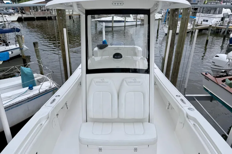 Slide: The Image of 2020 Regulator 24XO boat docked at marina, featuring white seating and console. - 4