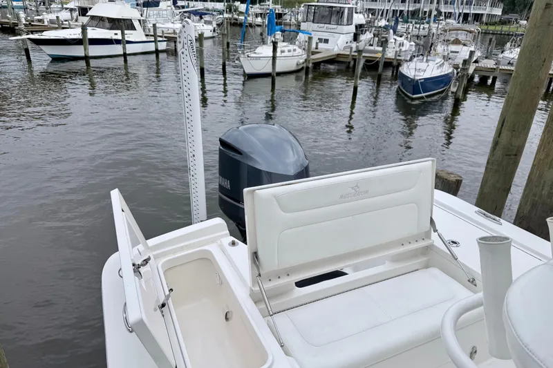 Slide: The Image of 2020 Regulator 24XO boat docked, featuring Yamaha engine and open storage compartment. - 5