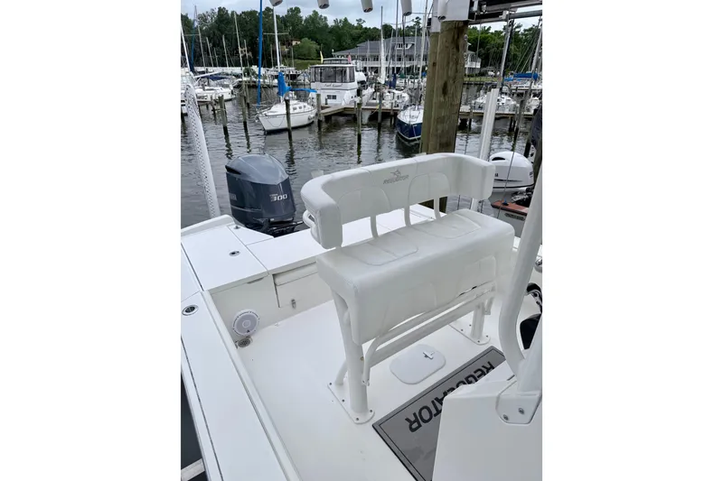 Slide: The Image of 2020 Regulator 24XO boat with seating, docked at a marina with other boats. - 8