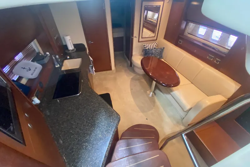 Slide: The Image of 2007 Sea Ray 40 Sundancer interior with kitchen, seating area, and wooden finishes. - 15