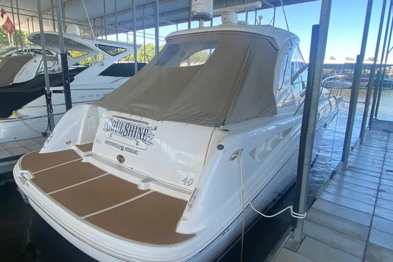 Slide: The Image of 2007 Sea Ray 40 Sundancer docked, featuring a tan canopy and spacious swim platform. - 2