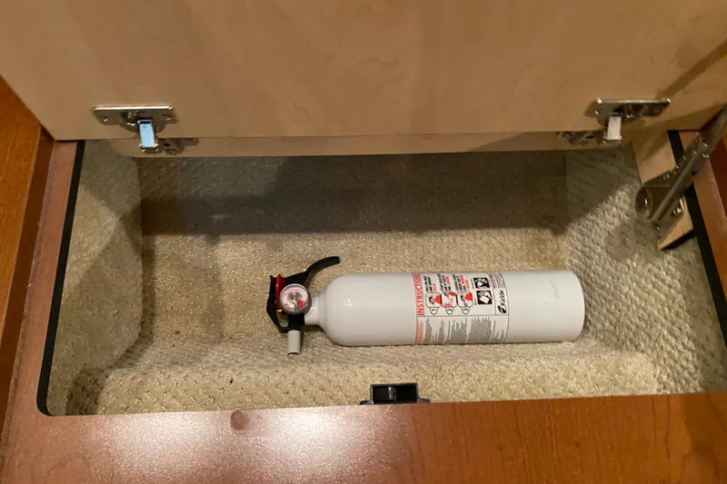 Slide: The Image of Fire extinguisher stored in a compartment of a 2007 Sea Ray 40 Sundancer boat. - 34