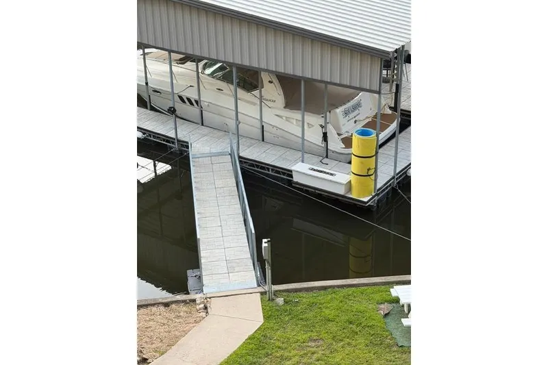 Slide: The Image of 2007 Sea Ray 40 Sundancer docked in a covered marina slip with walkway access. - 47