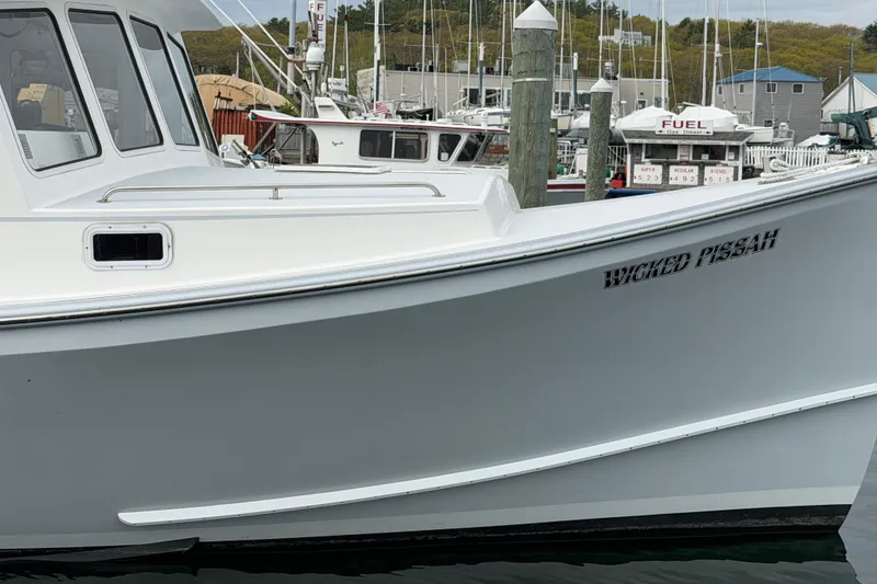 Slide: The Image of 2018 H&H Marine Osmond Beal boat named "Wicked Pissah" docked at a marina. - 14
